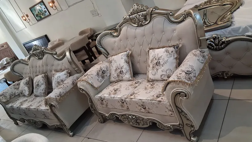 A carved silver-finish sofa suite with paisley brocade upholstery
