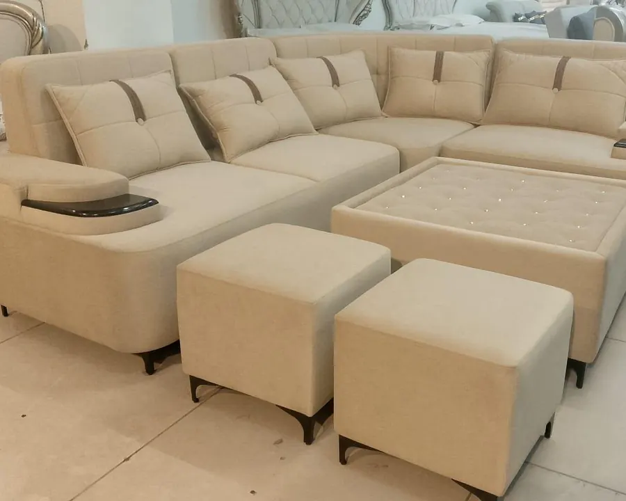 A cream L-shaped fabric sofa with ottomans on the showroom floor